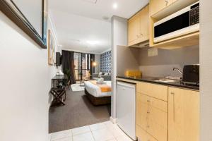a kitchen and living room with a bed in a room at KozyGuru | Haymarket | Stylish City Studio in Sydney