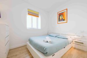 Un dormitorio blanco con una cama y una ventana. en Granville centre - Duplex 6 pers, en Granville
