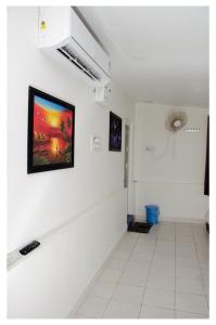 un couloir blanc avec un tableau sur le mur dans l'établissement Mubeen beach villa, à Pondichéry