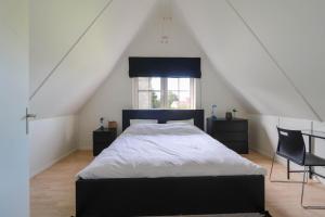 ein Schlafzimmer mit großem Bett und Fenster in der Unterkunft Beachvilla - 5 personen in Holle Poarte