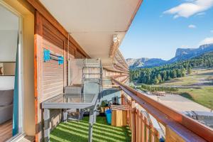 balcón con silla y vistas a las montañas en Appartement Tout Confort, en Superdevoluy