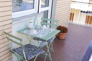 une table et deux chaises assises sur une terrasse couverte dans l'établissement Borgo Navile Apartment, à Turin 15 autres photos