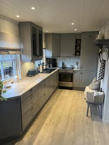 a kitchen with gray cabinets and a wooden floor at Hovden Alpin Apartments in Bykle