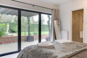 a bedroom with a large glass door and a bed at Two bedroom house with far-reaching country views in Sheering
