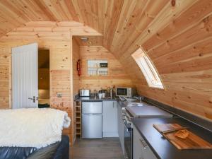 a kitchen in a log cabin with wooden walls at Barcud Coch - Uk44539 in Hirnant