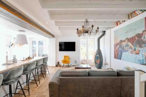 a living room with a couch and a bar with stools at Les coques bleues in Granville