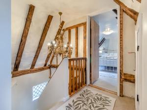 a staircase in a house with a chandelier at All Saints Cottage in Saffron Walden +16 photos