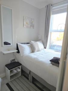 a bedroom with a large bed with a window at Sunflower in London +2 photos