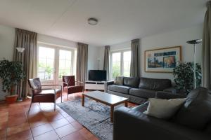 ein Wohnzimmer mit Sofa und Tisch in der Unterkunft Beachvilla - 8 personen in Holle Poarte