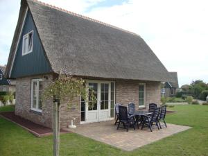 a house with a table and chairs in front of it at Beachvilla - 8 people in Makkum +17 photos