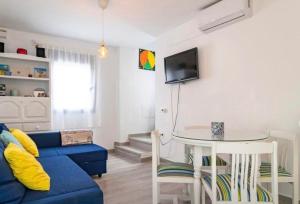 a living room with a blue couch and a table at La Triniá in Conil de la Frontera