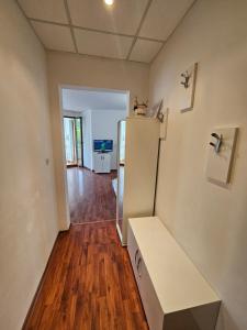 a room with a white refrigerator and a wooden floor at Апартамент Перла in Sandanski