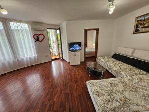 a living room with a couch and a tv at Апартамент Перла in Sandanski
