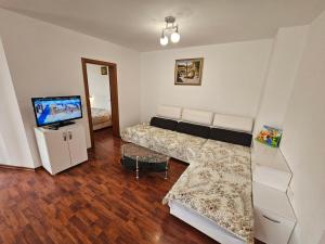 a living room with a couch and a television at Апартамент Перла in Sandanski