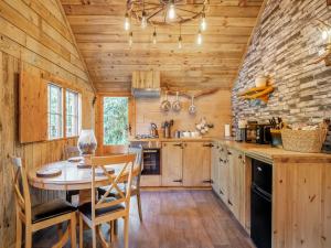 a kitchen with a table and chairs in a cabin at The Retreat - Uk50421 in Bisterne