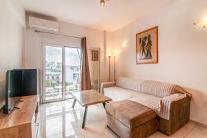 a living room with a couch and a tv at ACROPOLIS CASA Historic Centre Top Floor Elegant Stylish Retreat 150m to Metro & Attractions in Athens