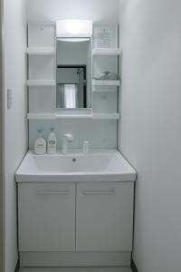 a white bathroom with a sink and a mirror at r8 最大8名対応 なんば 道頓堀そばの広々ルーム in Osaka