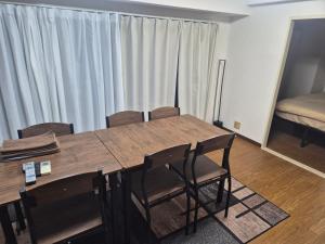 a room with a wooden table and chairs at r8 最大8名対応 なんば 道頓堀そばの広々ルーム in Osaka +8 photos