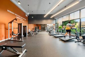 a woman running on a treadmill in a gym at Chic 4-Bedroom with Skyline Views & Amenities in Chicago