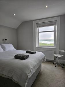 a bedroom with a large bed and a window at Atlantic Sea View in Portstewart
