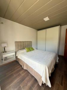 a bedroom with a large bed with green pillows at Hermoso Dúplex de 2 dormitorios con jardín in Santa Fe