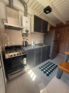 a kitchen with a stove and a sink in it at Hermoso Dúplex de 2 dormitorios con jardín in Santa Fe +5 photos