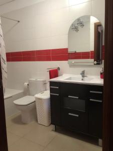 Un baño con inodoro, lavabo y espejo. en Alcalá Center Tenerife Canarias, en Guía de Isora