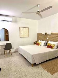 een slaapkamer met een groot bed en een stoel bij Sands Apartments in St Paul's Bay +77 foto's