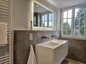 a bathroom with a white sink and a mirror at Stadtvilla Heimatliebe direkt am Park und citynah gelegen für bis zu 5 Personen, Haustiere willkommen in Nordhorn +32 photos
