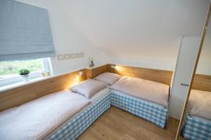 zwei Betten in einem Zimmer mit Fenster in der Unterkunft Villa am See für bis zu 6 Personen mit Kaminofen, Badewanne und Sauna - Haustiere herzlich willkommen, direkt am Wasser gelegen in Nordhorn