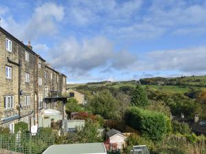 a row of houses in a small town with trees at Seamstress Cottage in Ripponden