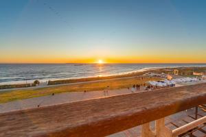 a view of the beach at sunset from a balcony at Eden on The Bay 250 in Bloubergstrand