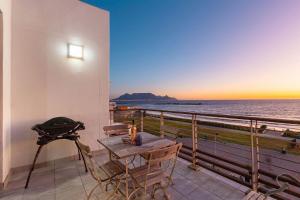 a table and chairs on a balcony with a view of the ocean at Eden on The Bay 250 in Bloubergstrand