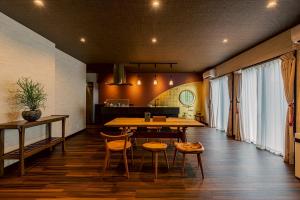 a room with a table and chairs and a kitchen at Private hot spring Villa Origami in Minamiizu +92 photos