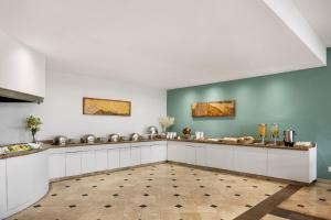 a kitchen with white cabinets and green walls at Fiesta Inn Express Nuevo Laredo in Nuevo Laredo +23 photos