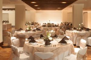 a banquet hall with white tables and white chairs at Fiesta Americana Aguascalientes in Aguascalientes +42 photos