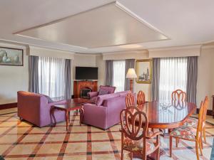 a living room with purple furniture and a table at Fiesta Americana Aguascalientes in Aguascalientes