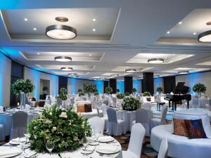 ein Ballsaal mit weißen Tischen und Stühlen und einem Flügel in der Unterkunft Live Aqua Cancun - Adults Only - All-Inclusive in Cancún + 219 Fotos