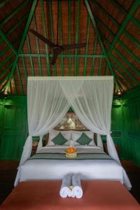 a bedroom with a bed with two slippers on it at Sokwayah Jungle Villas & Retreat in Ubud +36 photos