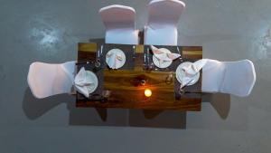 a table with white chairs and a candle on it at Wayma Paradise Resort in Jambiani