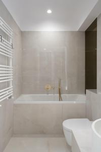 ein weißes Badezimmer mit Badewanne und Toilette in der Unterkunft Studio Quattro Cortina North Stay in Voluntari + 32 Fotos