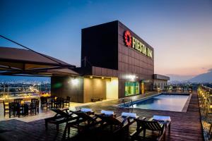 a hotel with a pool and tables and chairs at Fiesta Inn Monterrey Fundidora in Monterrey