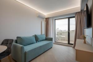 ein Wohnzimmer mit Couch und großem Fenster in der Unterkunft Studio Quattro Cortina North Stay in Voluntari