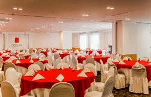 a conference room with red and white tables and chairs at Fiesta Inn Tlalnepantla in Mexico City