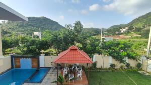 a backyard with a swimming pool and a gazebo at Ananda stays in Debāri
