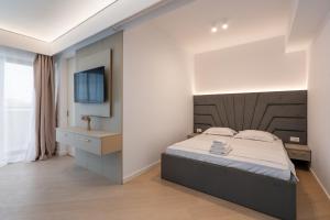 ein Schlafzimmer mit einem Bett und einem Waschbecken sowie einem TV in der Unterkunft Studio Quattro Cortina North Stay in Voluntari