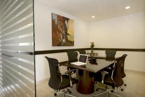 a dining room with a table with a laptop on it at One Aguascalientes Sur in Aguascalientes