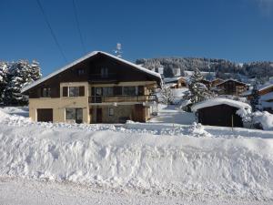 een huis bedekt met sneeuw met een berg sneeuw bij Chalet Le Starfu in Crest-Voland