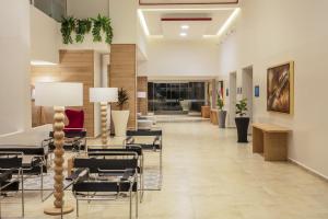 a hallway with chairs and tables in a lobby at Fiesta Inn Celaya Galerias in Celaya