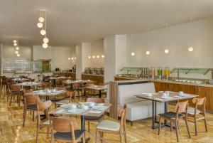 a restaurant with tables and chairs and a counter at Fiesta Inn Guadalajara Periferico Poniente in Guadalajara +28 photos